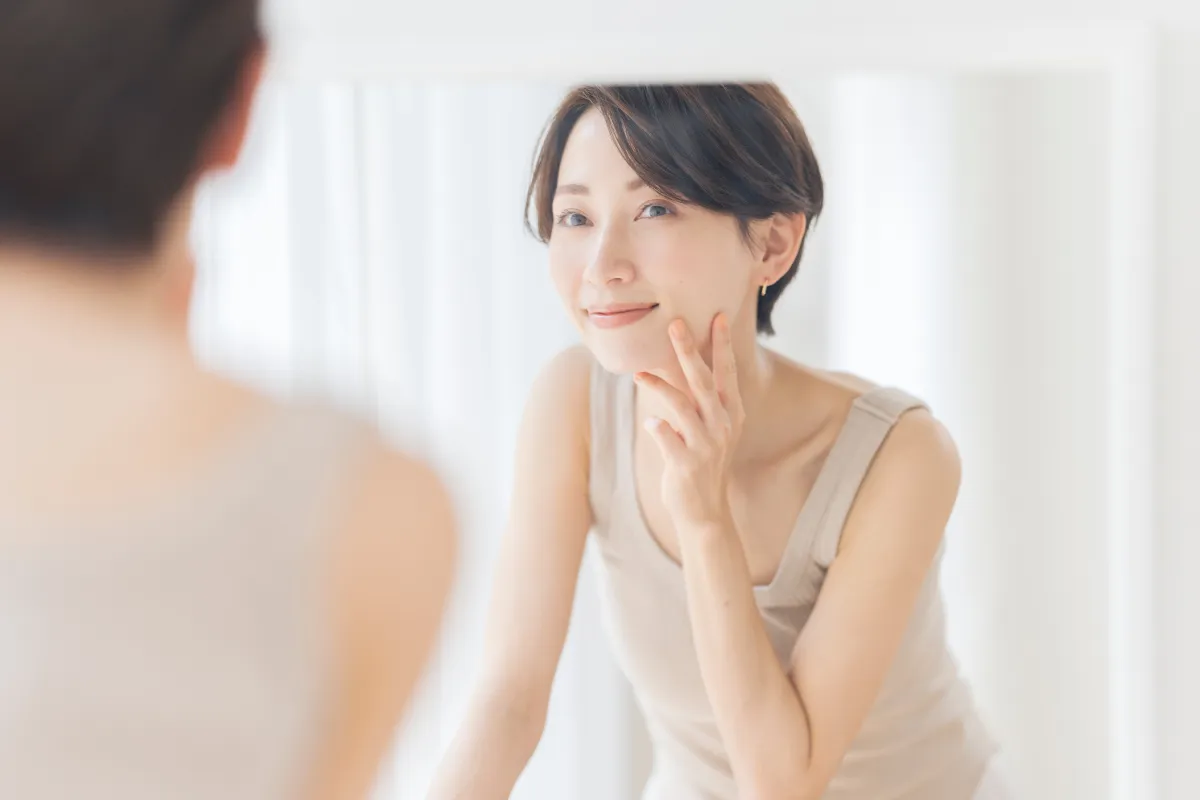鏡で口元の様子を確認している女性